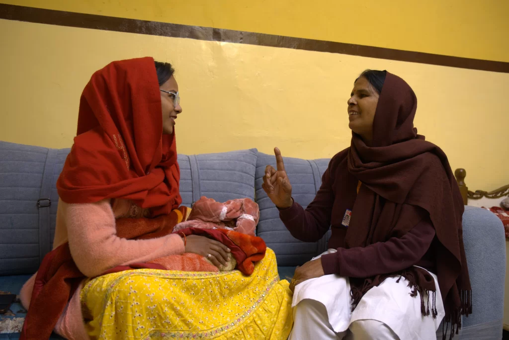 Mother and child at a health facility, or a frontline health worker interacting with a beneficiary